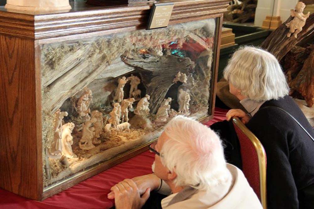 Friends of Creche members examining nativity