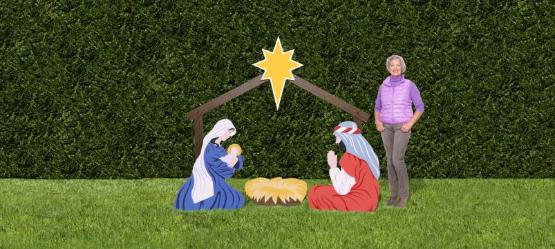 woman standing next to life-size outdoor nativity